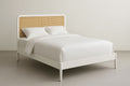 White wooden double bed with cane headboard